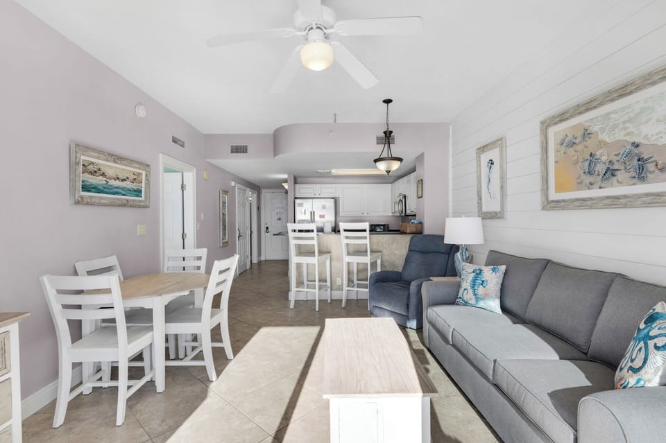 Living Room -Step into coastal luxury with this airy beachfront living room, boasting cozy seating, a large flat-screen TV, and endless ocean views for total comfort.