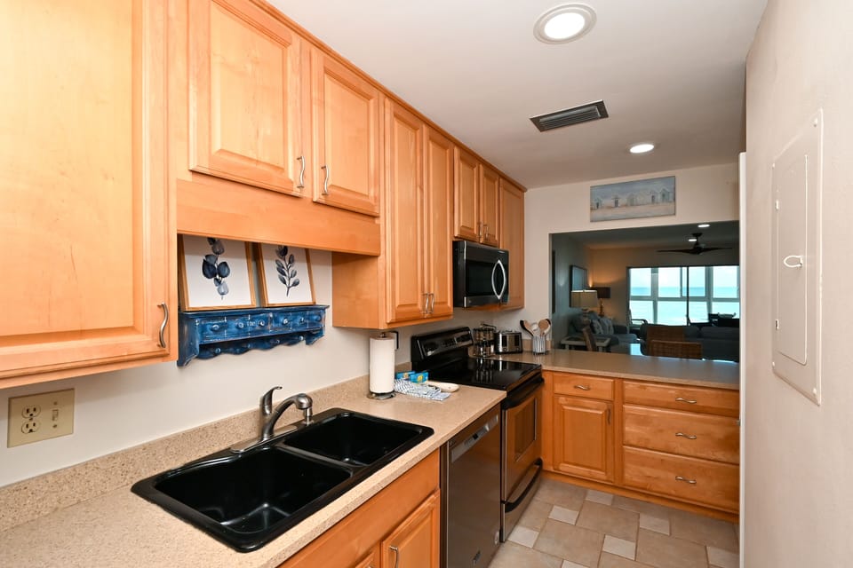 Modern, renovated kitchen, opens to living/dining area and window/door overlooking the bay and boat docks