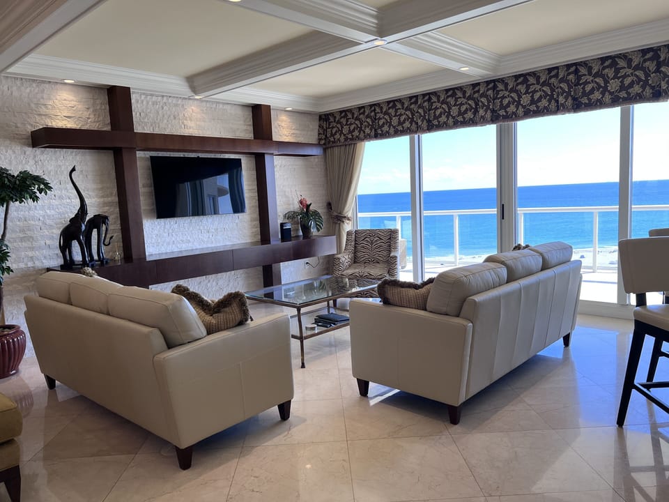 Elegant oceanfront Living Room with floor‑to‑ceiling windows / balcony sliders.