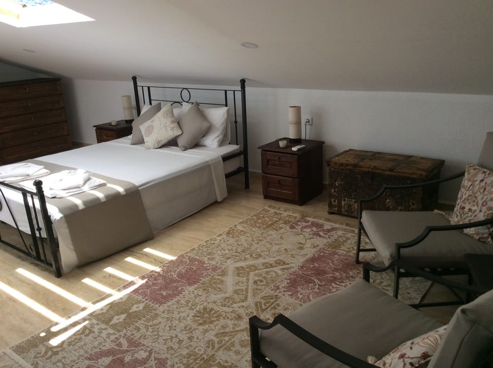 Top Floor bedroom with comfortable seating area and antique Ottoman chest