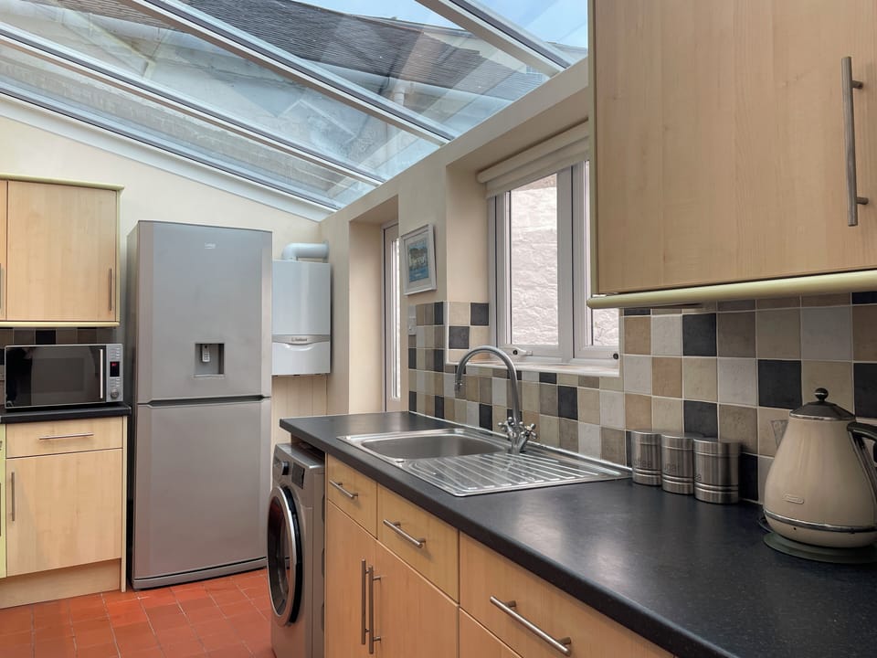 Kitchen showing Fridge/Freezer, microwave, combined washing machine/tumble dryer