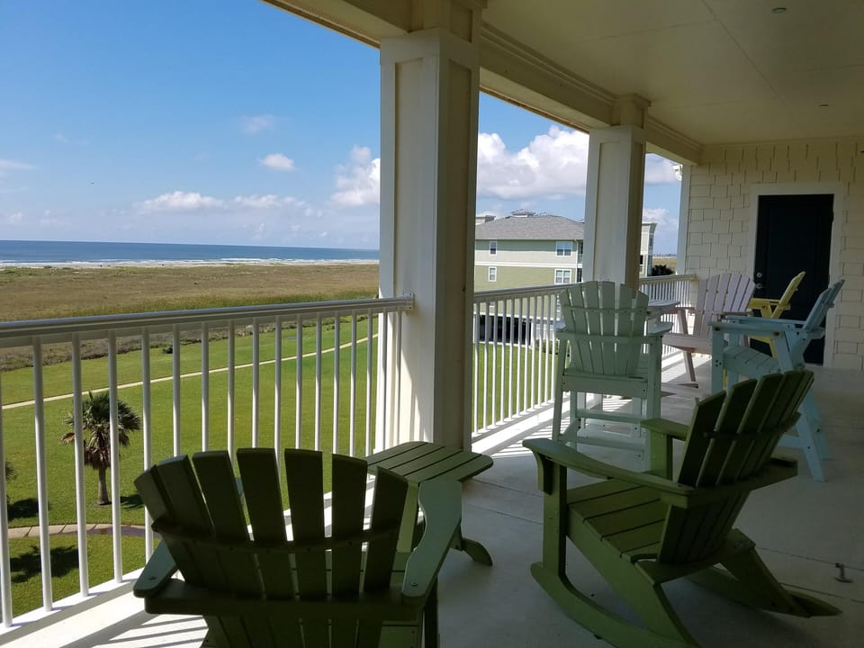 Balcony with 4 bar stool chairs and table, 2 rocking chairs and small table.