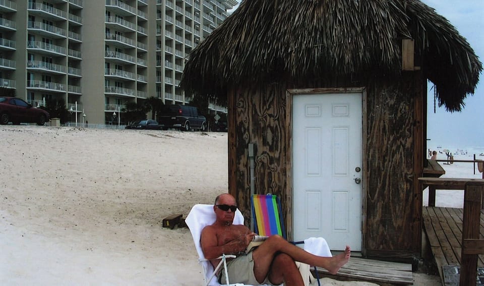 pops enjoying a cold drink at the tiki bar on the beach