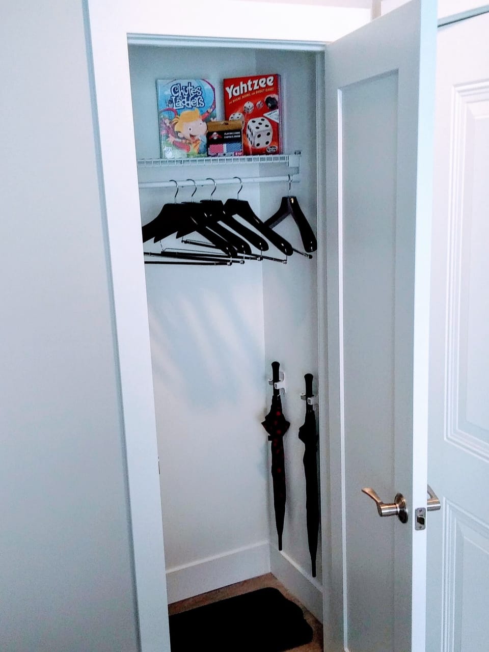 Umbrella and games in entrance closet.