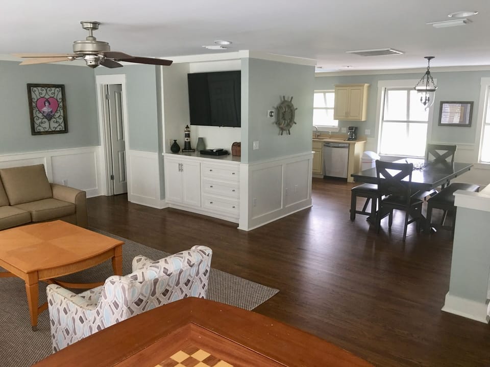 East side den and dining area has 2 couches and a swivel chair