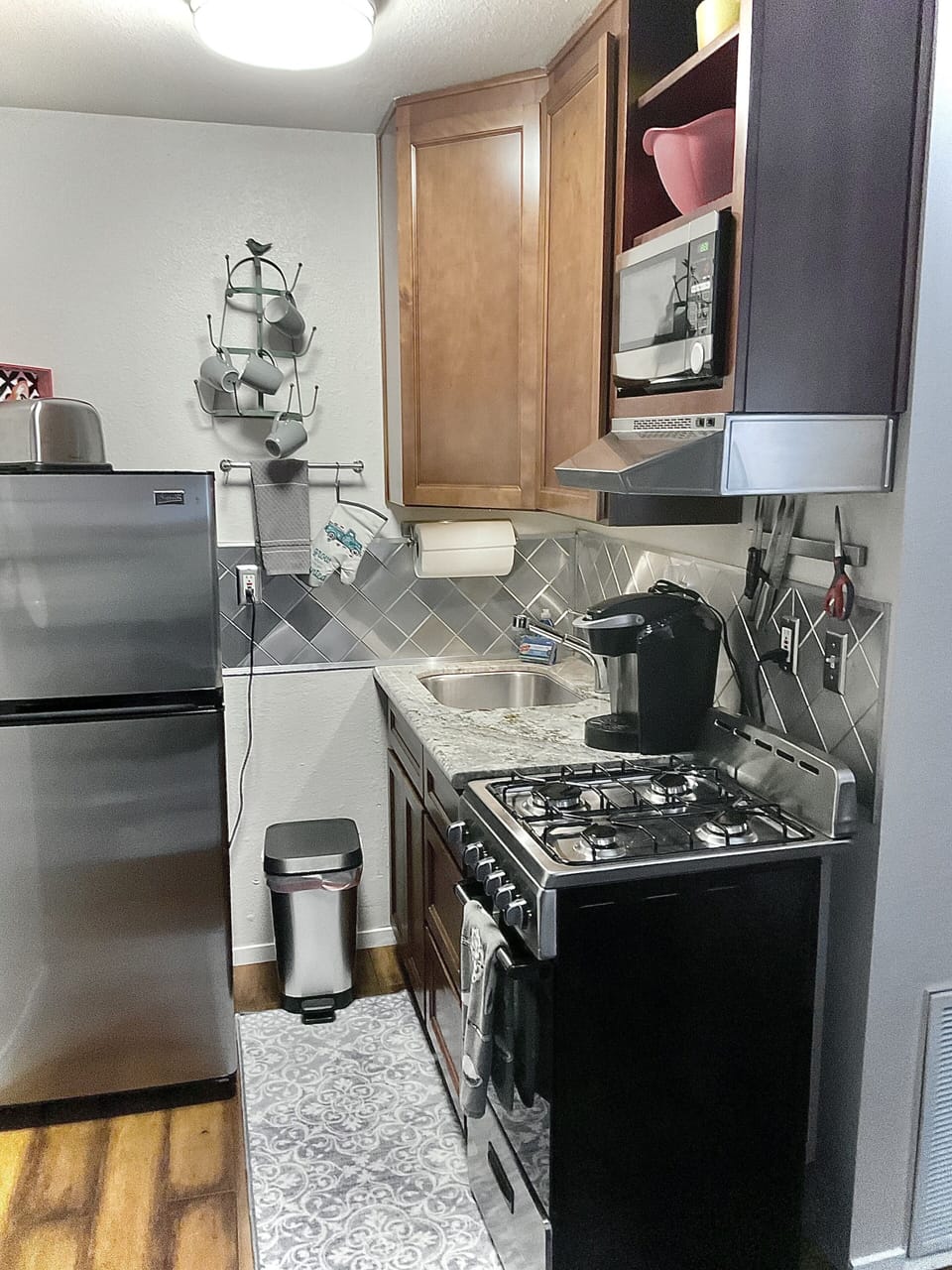 Kitchen with Gas range, micro, refrigerator, pots and pans.