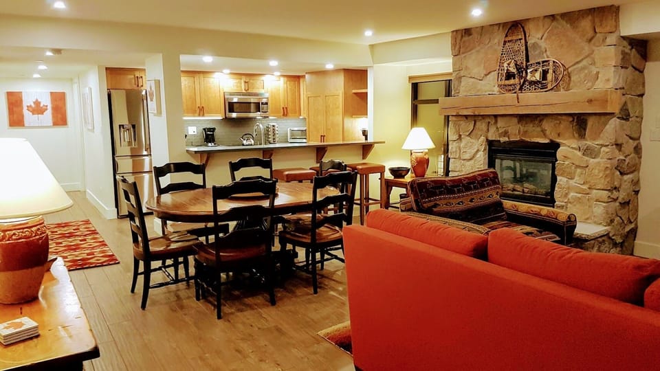 Dining area with bar seating and kitchen in the background.