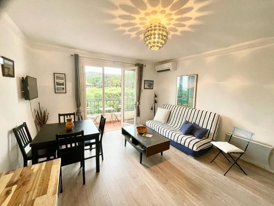 Living room and dining area, with balcony with sea view visible