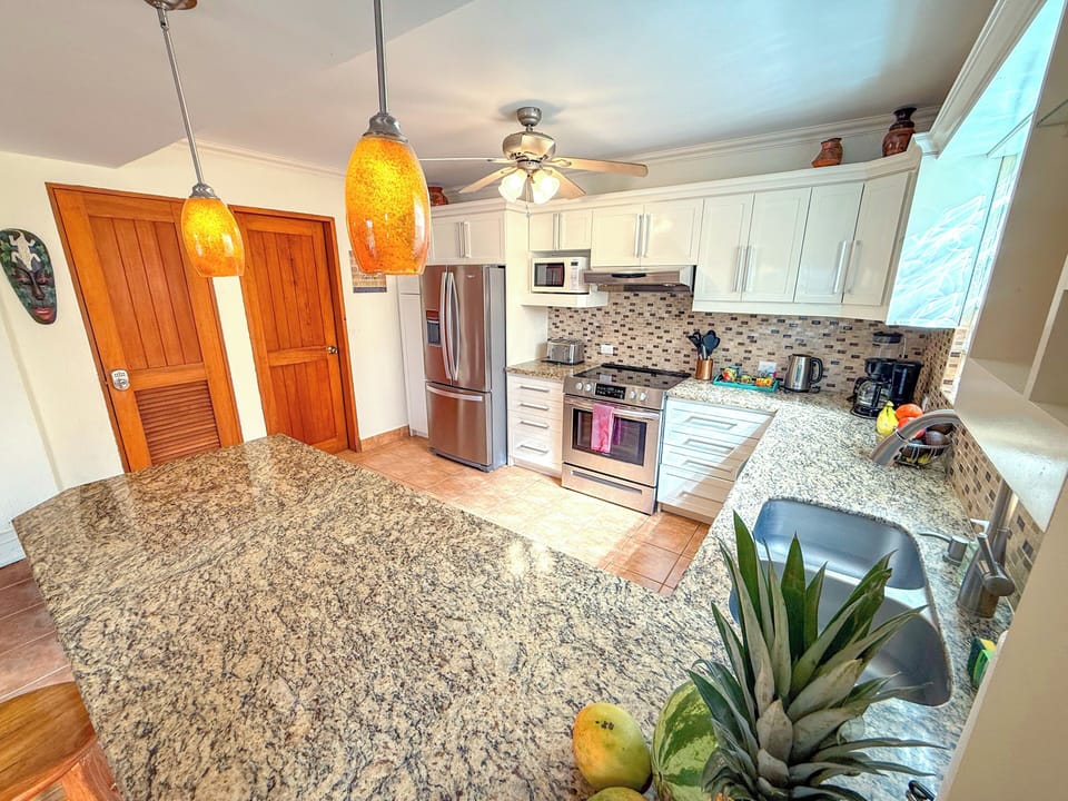 Warm and welcoming kitchen with glass block windows with amber pendant lights.