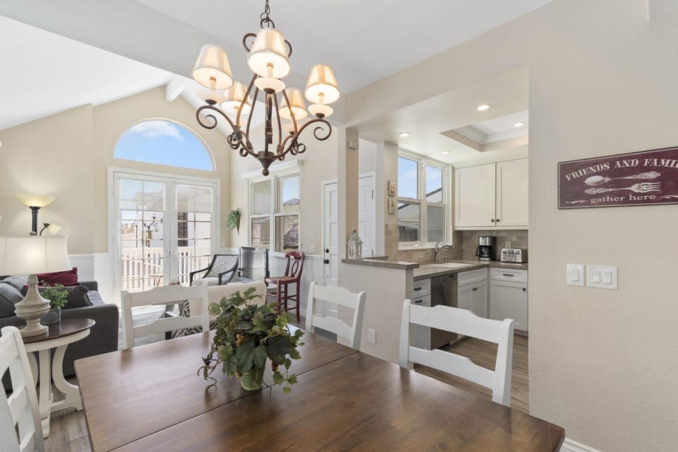 Vantage point from dining table and seating toward kitchen, living room and TV. Wood-look tile flooring throughout all living spaces.
                