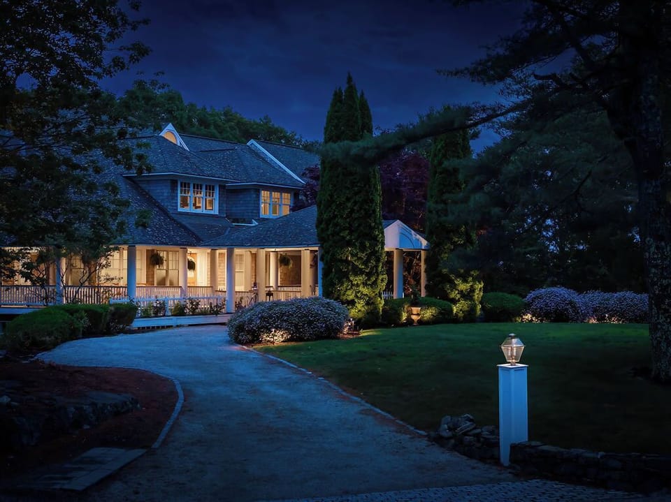 A warm welcome awaits as the estate glows beautifully at dusk, surrounded by peaceful, landscaped grounds.