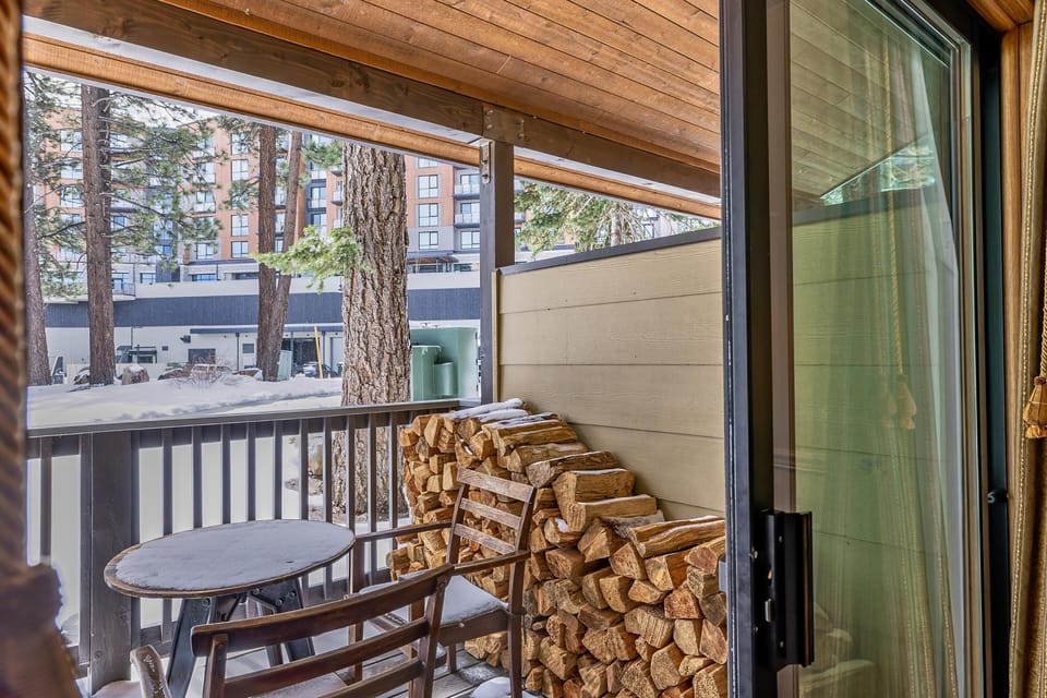 Step out to the sheltered terrace where seasoned firewood, hand-hewn rockers, and frosted treetops set an alpine mood.