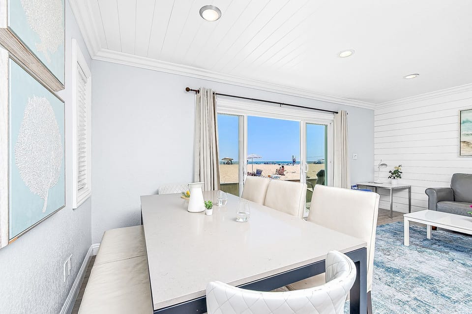 The front door opens into the main living area, which includes sofa and upholstered side chair seating, cable TV, and dining table w/ seating for 6.
                