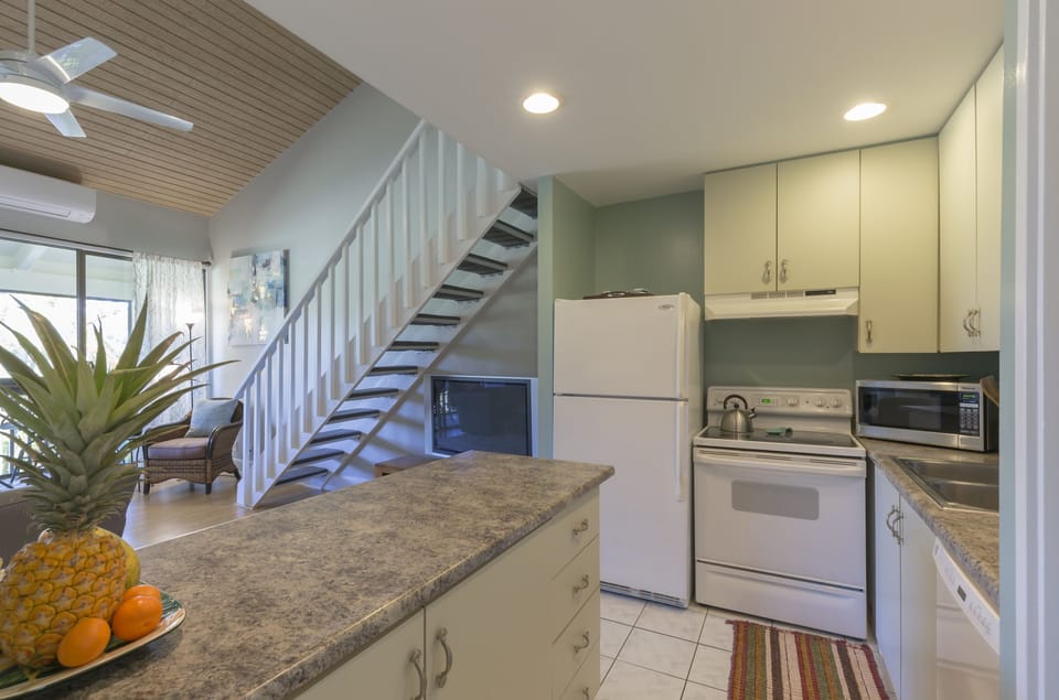 Kitchen opening to living room, screened lanai, and spacious loft bedroom
