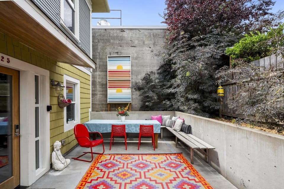 Entrance to the lower unit is behind the house and down a few stairs with a lovely patio.