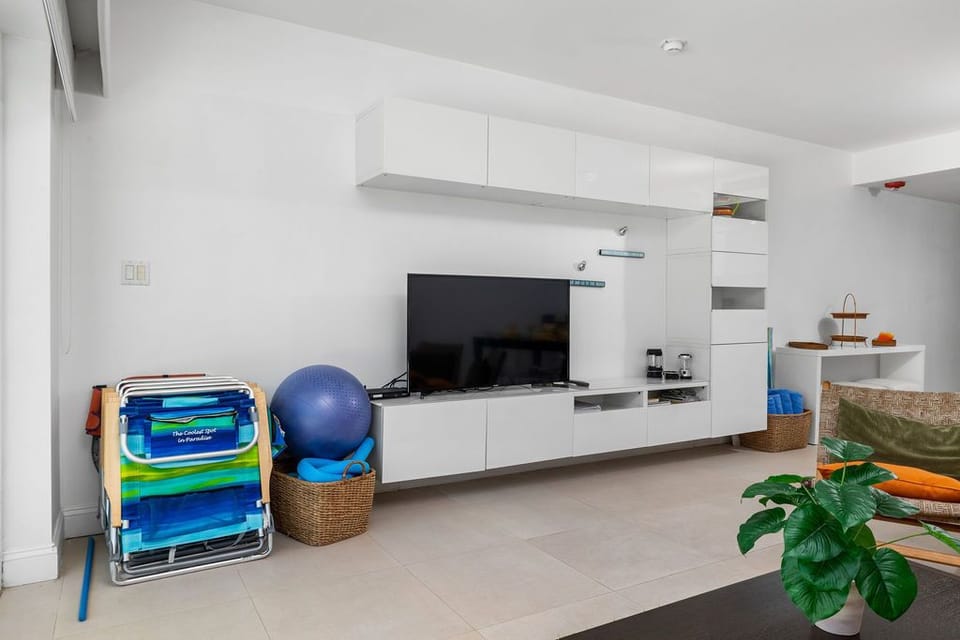 Your bright living space features sleek modern storage, a flat-screen TV for movie nights, and fun beach gear ready for your sunny adventures.