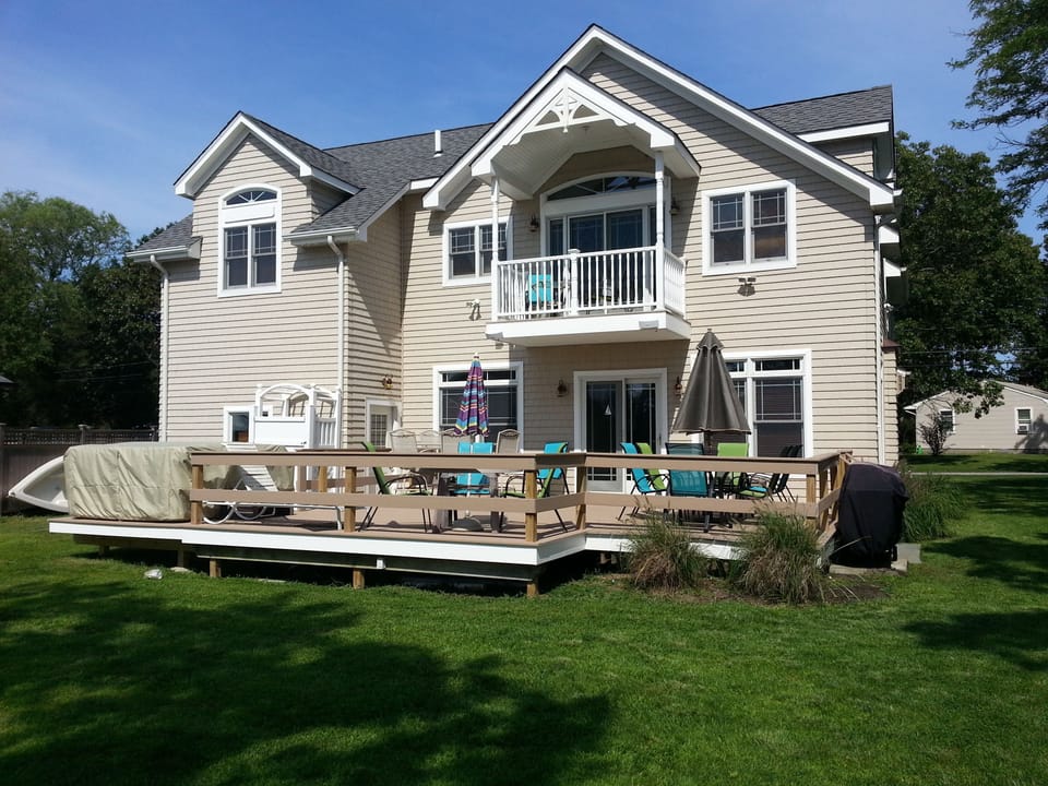 Hot tub (covered)and outdoor shower (white) on left.  Gas grill on right.