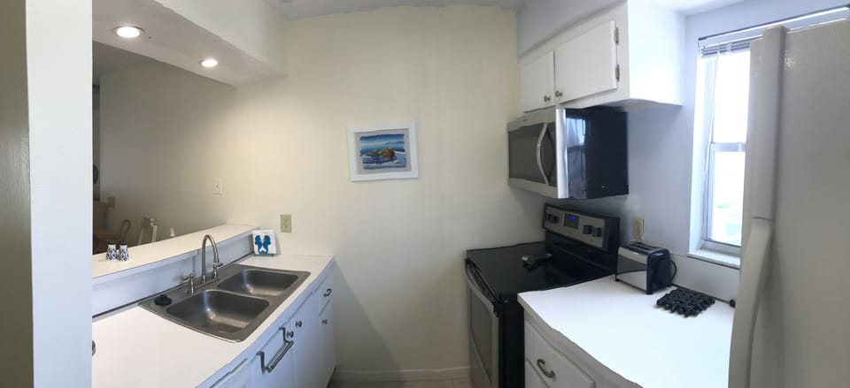 Whirlpool glass top stove & above range microwave in Galley style kitchen