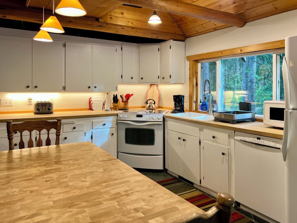Full kitchen well stocked for cooking.