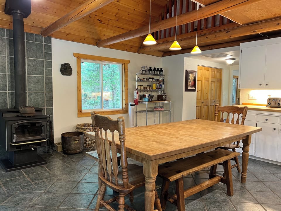 Kitchen with eating area and glass door wood stove for cozy cabin vibes.