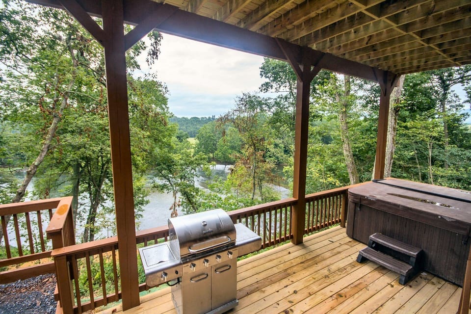 Hot tub and gas grill overlooking river, large open gathering areas around house