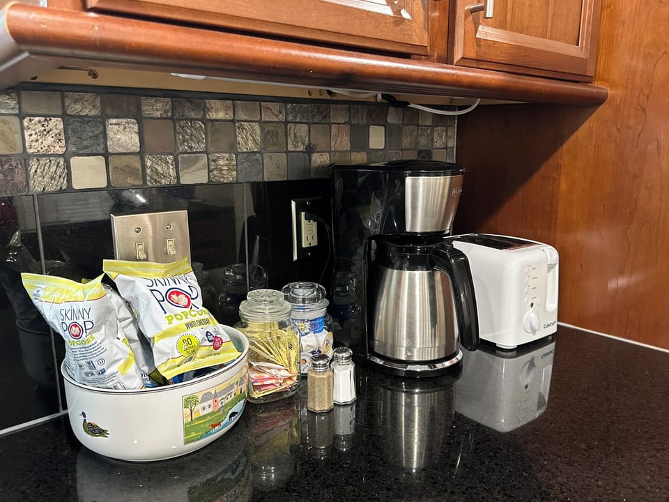 Coffee pot, toaster, blender, salt/pepper, snacks. Coffe/tea packets in drawer.