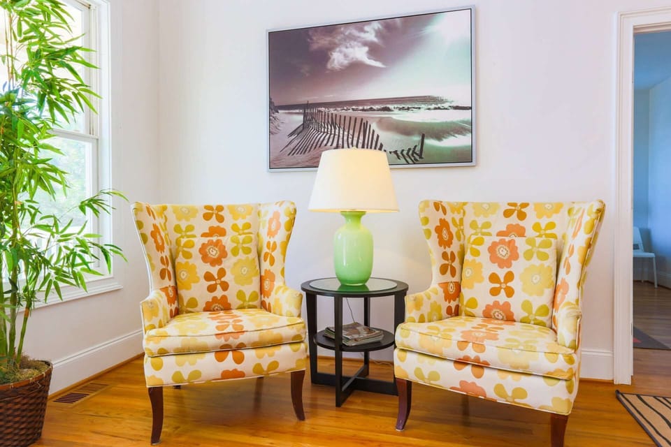 The master bedroom is located on the first floor just behind this seating area near the front door.