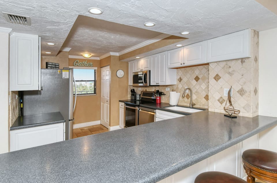 Modern updated kitchen granite counter tops, tile backsplash,  and all stainless steel appliances