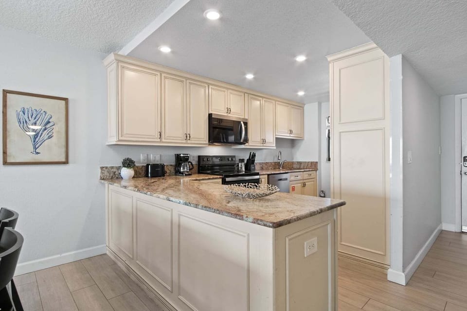 Spacious kitchen with classic cabinetry, granite countertops, and modern appliances.