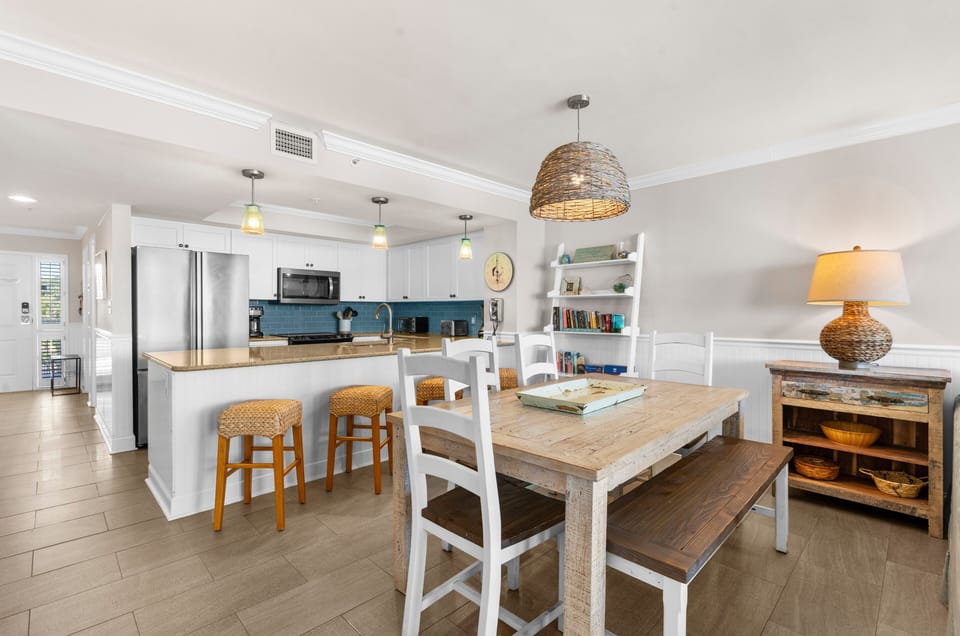Gather together with ease at the dining table featuring seating for six, plus additional bar seating for four, perfect for family meals, game nights, and casual conversations after a day at the beach.
