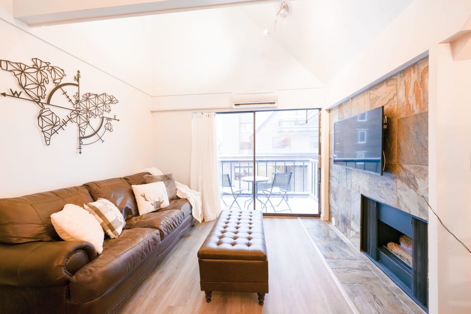 Cozy living room area with fireplace, HDTV, and view of the mountain.
