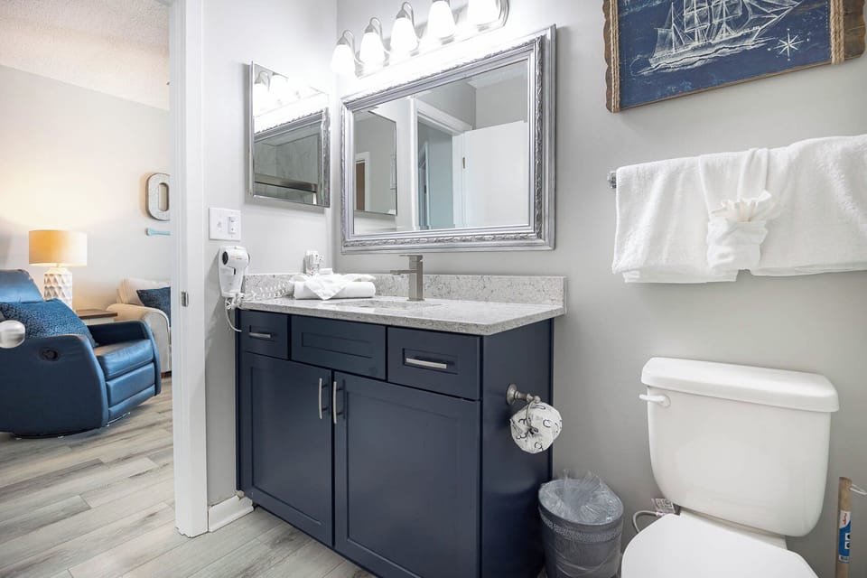 Experience a stylish bathroom with a modern vanity and walk-in shower, accessible from the living space and bedroom