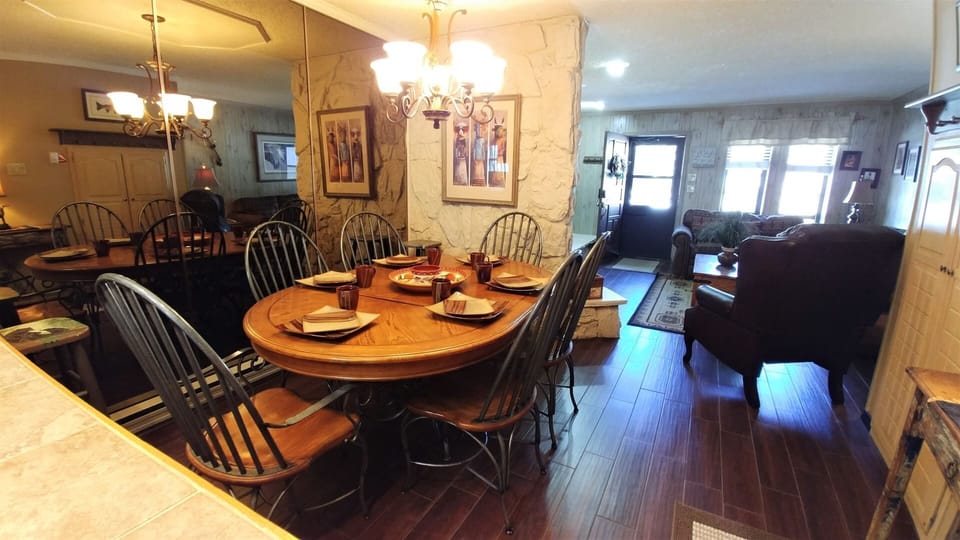 Step into your spacious retreat where meals and memories flow effortlessly. Gather around the welcoming dining table set for your group, then unwind in the cozy living area—all bathed in natural light.