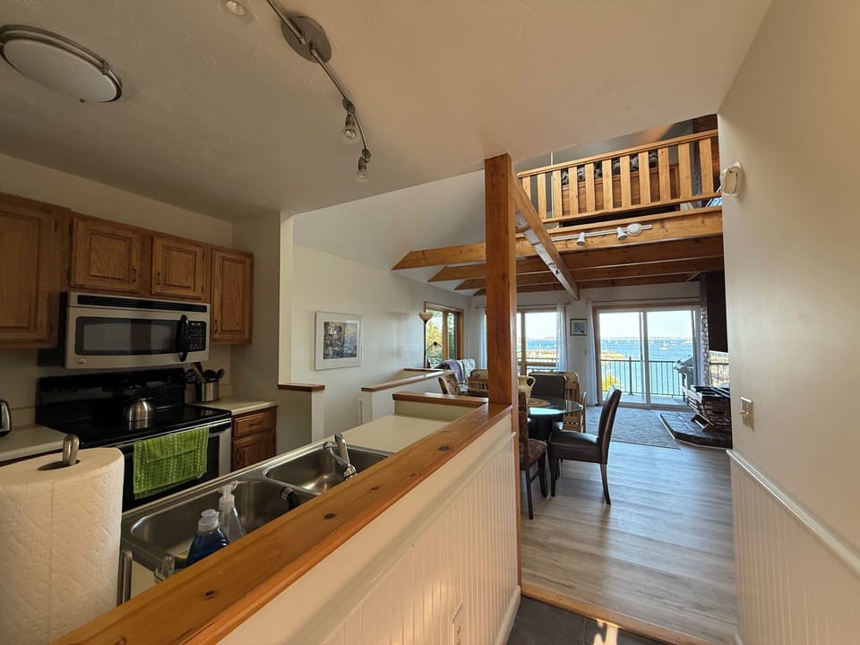 Entry way view from front door to midlevel kitchen, dining, living, outdoor deck