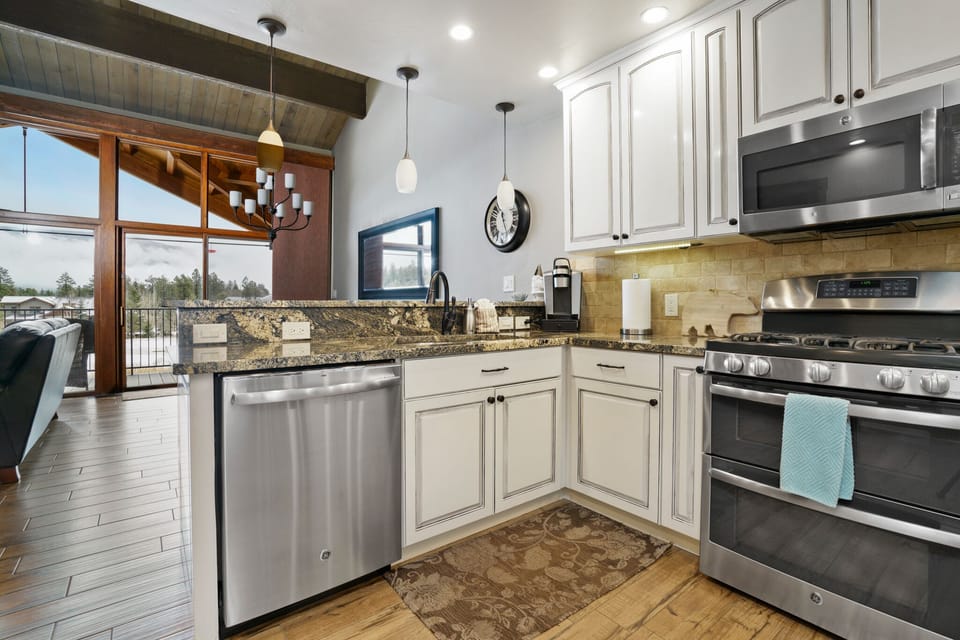Kitchen opens up to living and dining area with picturesque view