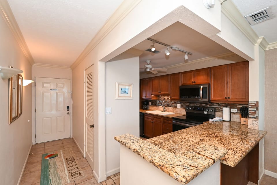 Modern, renovated, fully equipped kitchen with granite counters, glass tile backs splash...