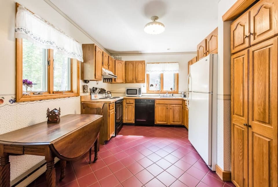 The kitchen now has an extended counter with barstools instead of the small table..