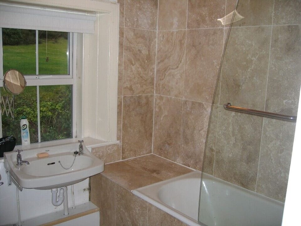 Bathroom. Full size bath; travertine and shower.