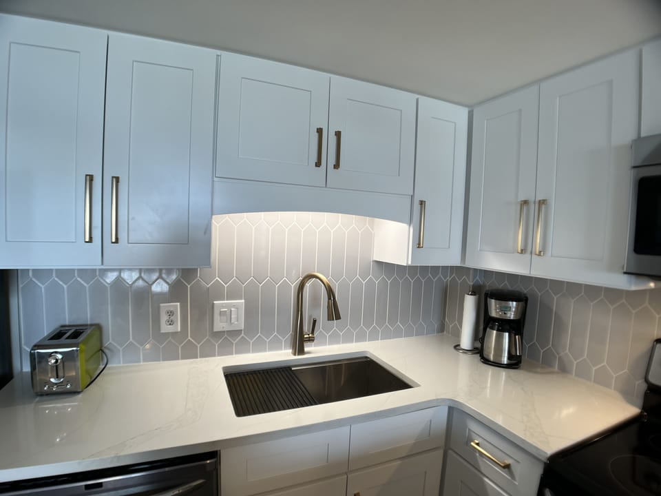 White quartz, Gray picket tile backsplash, Champagne bronze finishes.