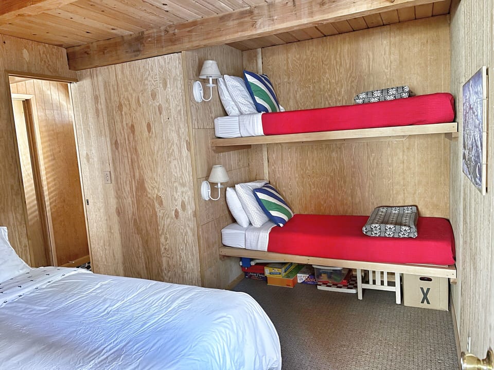 Main floor bedroom with queen bed and bunks