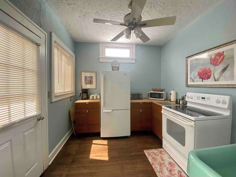 Bright separate kitchen with bottom freezer fridge and butcher block counters