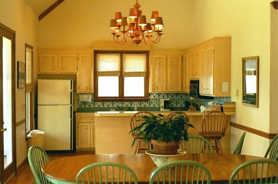 Open floor plan with a view of the well stocked kitchen and dining table.