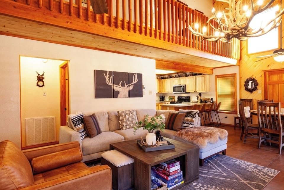 Unwind in your spacious cabin with soaring ceilings, rustic wood beams, and a cozy open layout. Curl up on plush seating, cook in your full kitchen, and enjoy mountain-inspired charm.