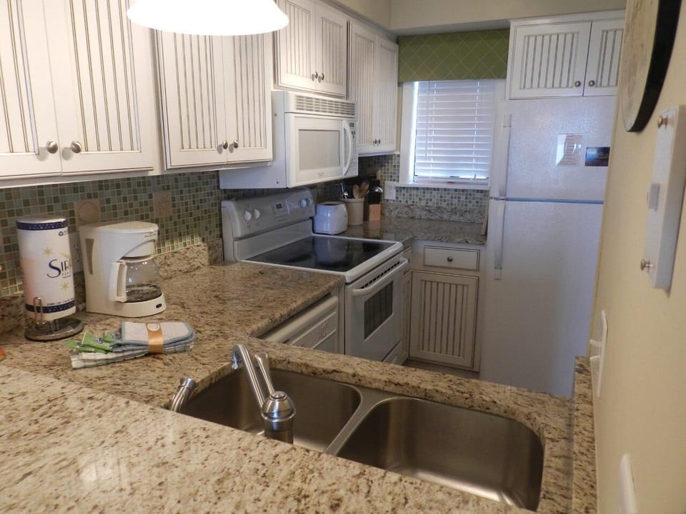 Full kitchen with granite counters & tiled backsplash