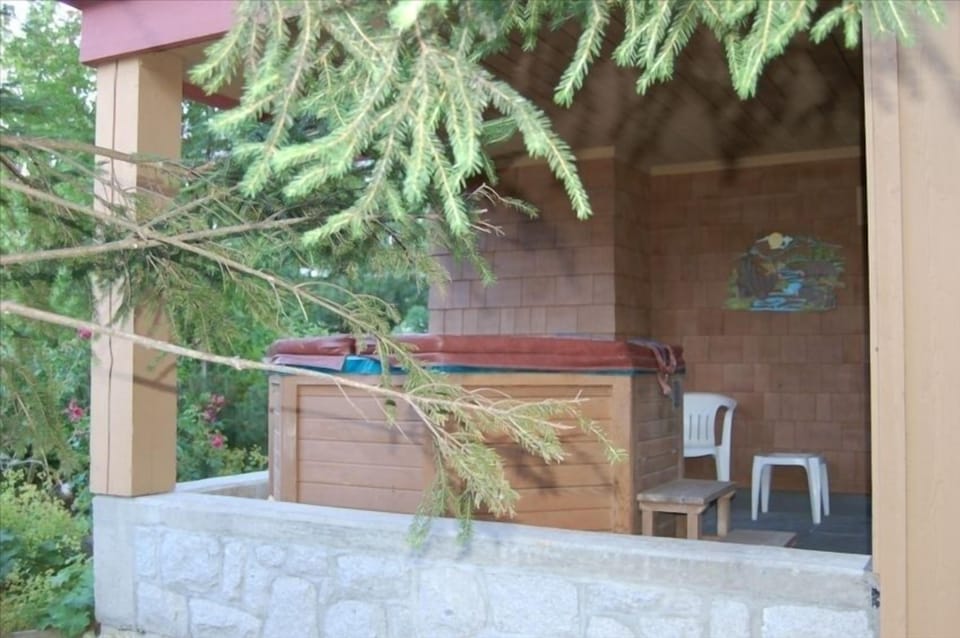 Large hot tub right outside patio on covered deck, truly private view of woods