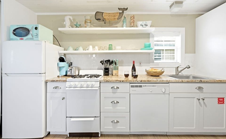 Galley kitchen with a gas range, dishwasher, refrigerator, and generous counter space.