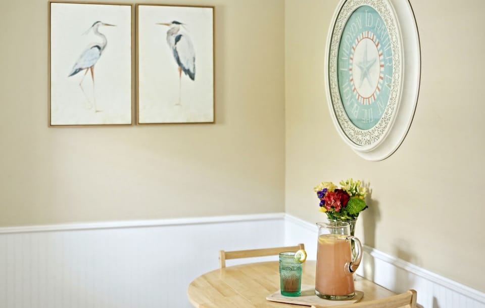 Cozy dining table for two with coastal artwork.
