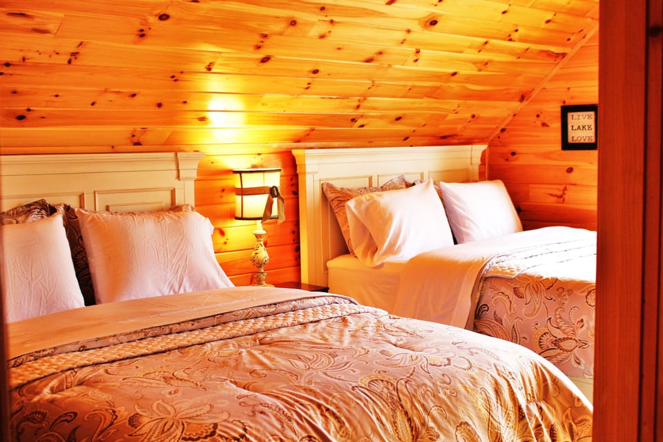 Upstairs Bedroom with two queen beds, luxury linens, view of the lake