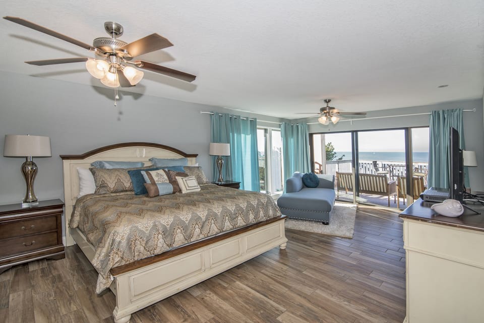 Main bedroom with king size bed, desk and chaise lounger over looking the beach