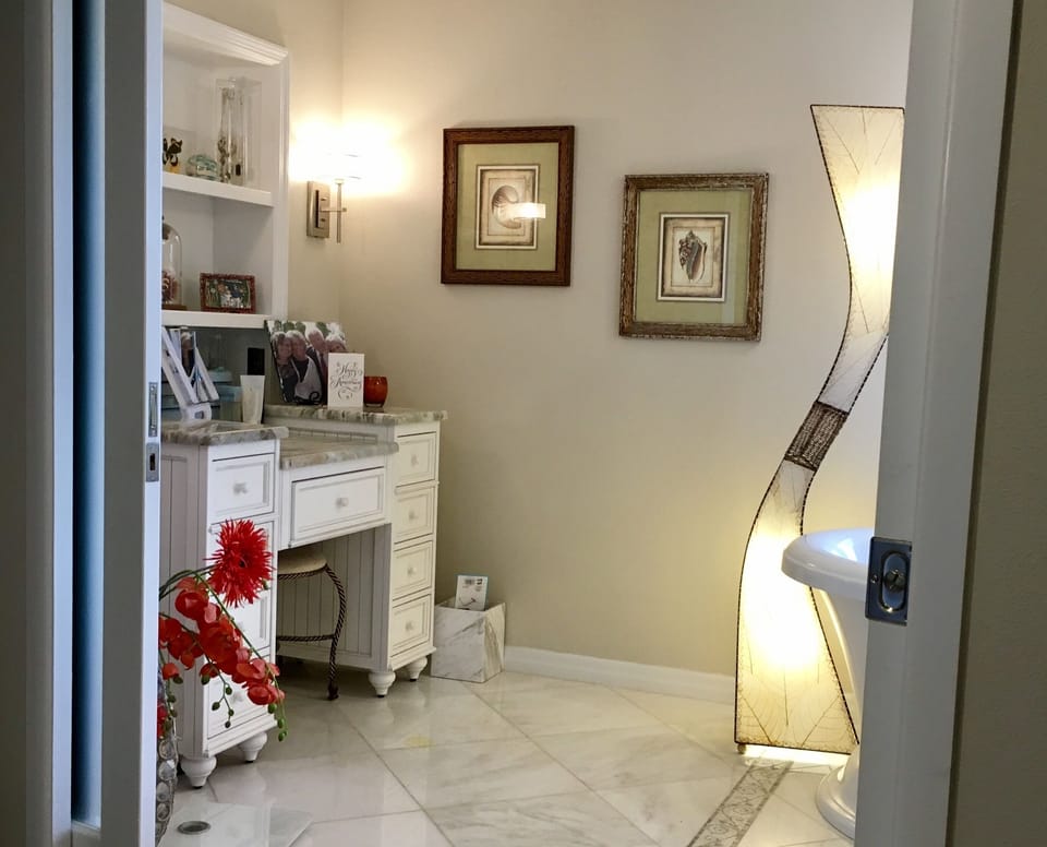 Main master bath has a makeup table. Bathroom has sliding frosted pocket doors. 